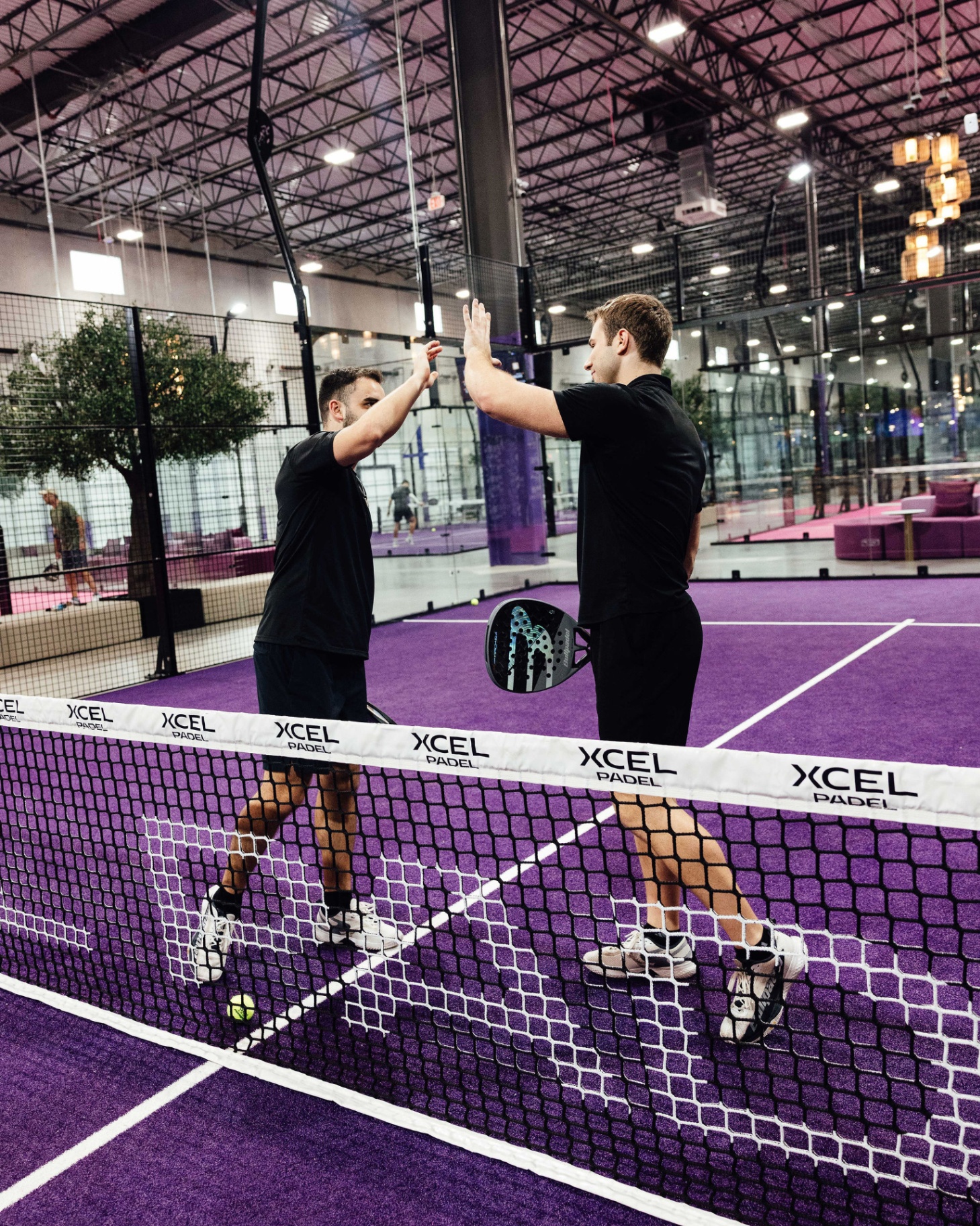 Members socializing at a padel club at sunset